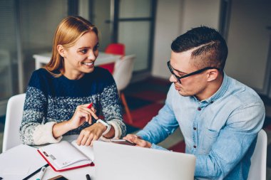 Genç öğrenciler fro kampüs içinde oturan birlikte iyi bir ruh hali içinde görev tamamlama sınavları hazırlık teknolojisini kullanarak Office işbirliği zevk proje hakkında konuşmayı olumlu iş arkadaşları