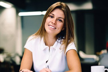 Sanat academie çizimler oluşturmak için modern teknolojiyi kullanarak, neşeli genç kız öğrenci yazma kitaplığındaki masada oturan dijital tablet kalemi kullanarak hippi kız gülümseyerek portresi