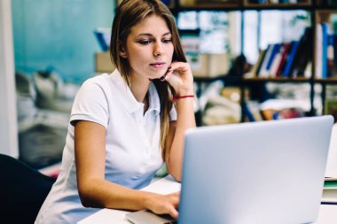 Kız öğrenci Kitaplığı ' nda sınavlarına otodidakt programı dersleri netbook yoluyla öğrenme e üzerinden zaman harcama akıllı hippi kız hazırlayın eğitim webinar online dizüstü bilgisayar izlerken konsantre