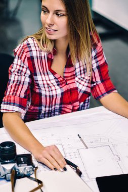 İleti örneği ve yaratıcı proje, zeki kız öğrenci uzak accountings grafikle çizerken seyir ders tamamlama üzerinde planları ile masaüstünde oturan genç kadın mimar