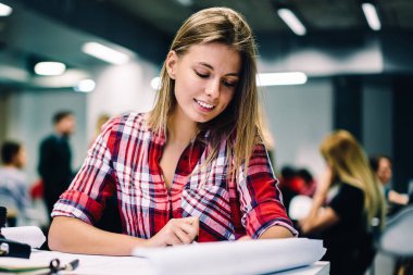 Genç kız öğrenci yaratıcı fikir sahip proje tasarlamak için kroki çizim gülümseyen, pozitif kadın mimar inşaat alanı coworking çalışma için plan hazırlanması ile memnun