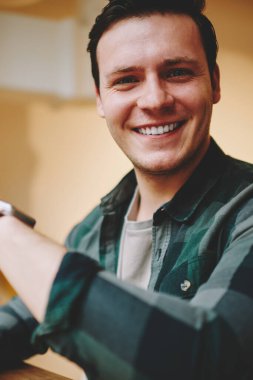 Bilek yararlı uygulamalar, mutlu erkek öğrenci kameraya seyir smartwatch özellikleriyle heyecan ile taşınabilir bilgisayarda modern dijital gadget giyen neşeli hipster adam portresi memnun