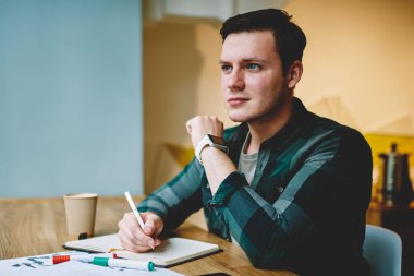 Not Defteri'nde, masaüstü Kırtasiye ve kağıtları ile oturma alanı coworking ödev proje yapıyor akıllı erkek öğrenci metin yazma makale oluşturma için fikir düşünüyorum yetenekli hipster adam