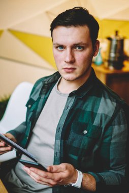 Genç raslantı giyimli erkek öğrenme bilgi klasörü, ciddi erkek kamera başlangıç alan coworking içinde belgelerin incelenmesi için planlama yapma bakarak tutan üniversite sınavlarına portresi