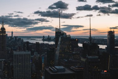 Manhattan 'ın merkezindeki gökdelenlerin ve kulelerin gökyüzü manzarası. Akşam günbatımında gökyüzü. Finansal bölgenin manzarası ünlü New York simgesi, aydınlanmış Empire State Binası