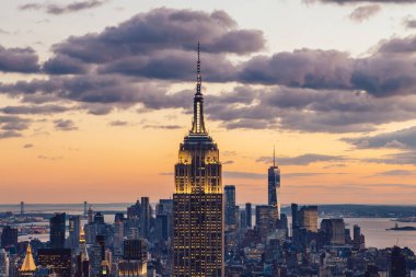 Manhattan 'ın merkezindeki gökdelenlerin ve kulelerin gökyüzü manzarası. Akşam günbatımında gökyüzü. Finansal bölgenin manzarası ünlü New York simgesi, aydınlanmış Empire State Binası