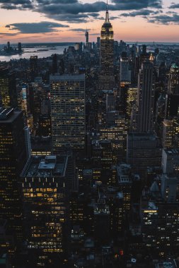 Manhattan 'ın merkezindeki gökdelenlerin ve kulelerin gökyüzü manzarası. Akşam günbatımında gökyüzü. Finansal bölgenin manzarası ünlü New York simgesi, aydınlanmış Empire State Binası