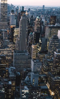 Manhattan 'ın merkezindeki gökdelenlerin ve kulelerin gökyüzü manzarası. Akşam günbatımında gökyüzü. Finansal bölgenin manzarası ünlü New York simgesi, aydınlanmış Empire State Binası