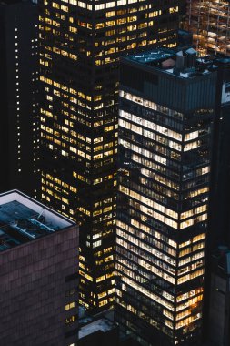 Manhattan 'ın çeşitli yüksek gökdelenlerinin gökdelenlerinin gökdelenleri. New York' ta akşam saatlerinde pencereleri açık olan binalar. Metropolis 'in gece hayatı, ofisler ve gayrimenkul. Şehir merkezindeki yapılar