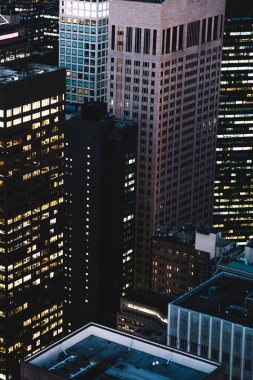 Manhattan 'ın çeşitli yüksek gökdelenlerinin gökdelenlerinin gökdelenleri. New York' ta akşam saatlerinde pencereleri açık olan binalar. Metropolis 'in gece hayatı, ofisler ve gayrimenkul. Şehir merkezindeki yapılar
