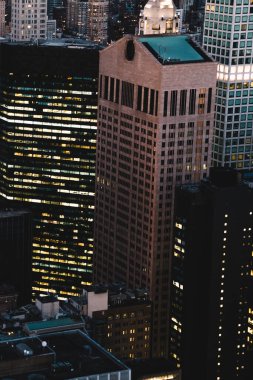 Manhattan 'ın çeşitli yüksek gökdelenlerinin gökdelenlerinin gökdelenleri. New York' ta akşam saatlerinde pencereleri açık olan binalar. Metropolis 'in gece hayatı, ofisler ve gayrimenkul. Şehir merkezindeki yapılar