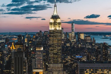 Manhattan 'ın merkezindeki gökdelenlerin ve kulelerin gökyüzü manzarası. Akşam günbatımında gökyüzü. Finansal bölgenin manzarası ünlü New York simgesi, aydınlanmış Empire State Binası