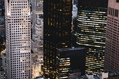 Manhattan 'ın çeşitli yüksek gökdelenlerinin gökdelenlerinin gökdelenleri. New York' ta akşam saatlerinde pencereleri açık olan binalar. Metropolis 'in gece hayatı, ofisler ve gayrimenkul. Şehir merkezindeki yapılar