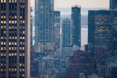 Manhattan 'ın çeşitli yüksek gökdelenlerinin gökdelenlerinin gökdelenleri. New York' ta akşam saatlerinde pencereleri açık olan binalar. Metropolis 'in gece hayatı, ofisler ve gayrimenkul. Şehir merkezindeki yapılar