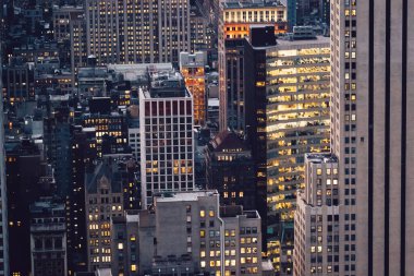 Manhattan 'ın çeşitli yüksek gökdelenlerinin gökdelenlerinin gökdelenleri. New York' ta akşam saatlerinde pencereleri açık olan binalar. Metropolis 'in gece hayatı, ofisler ve gayrimenkul. Şehir merkezindeki yapılar