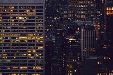 Manhattan 'ın çeşitli yüksek gökdelenlerinin gökdelenlerinin gökdelenleri. New York' ta akşam saatlerinde pencereleri açık olan binalar. Metropolis 'in gece hayatı, ofisler ve gayrimenkul. Şehir merkezindeki yapılar