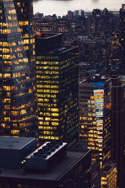 Manhattan 'ın çeşitli yüksek gökdelenlerinin gökdelenlerinin gökdelenleri. New York' ta akşam saatlerinde pencereleri açık olan binalar. Metropolis 'in gece hayatı, ofisler ve gayrimenkul. Şehir merkezindeki yapılar