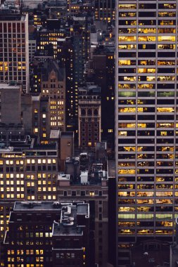 Manhattan 'ın çeşitli yüksek gökdelenlerinin gökdelenlerinin gökdelenleri. New York' ta akşam saatlerinde pencereleri açık olan binalar. Metropolis 'in gece hayatı, ofisler ve gayrimenkul. Şehir merkezindeki yapılar
