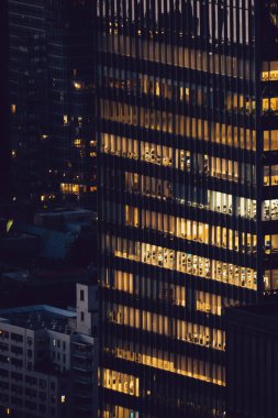 Manhattan 'ın çeşitli yüksek gökdelenlerinin gökdelenlerinin gökdelenleri. New York' ta akşam saatlerinde pencereleri açık olan binalar. Metropolis 'in gece hayatı, ofisler ve gayrimenkul. Şehir merkezindeki yapılar