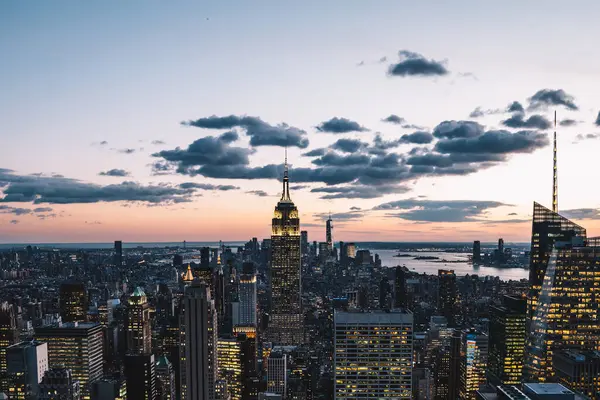 Manhattan 'ın merkezindeki gökdelenlerin ve kulelerin gökyüzü manzarası. Akşam günbatımında gökyüzü. Finansal bölgenin manzarası ünlü New York simgesi, aydınlanmış Empire State Binası