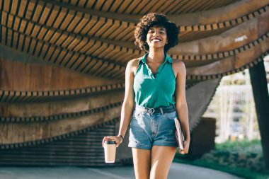 Güzel Afrikalı Amerikalı kaygısız kadın şehir planında eğleniyor güneşli bir bahar gününün tadını çıkarıyor. Şehir meydanında tatil yapmaktan memnun olan esmer tenli hippi kız.