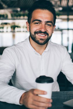 Kafeteryada dizüstü bilgisayarla oturan, mutlu, sakallı, mutlu bir erkek milenyumun portresi online olarak başarılı oldu.