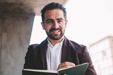 Resmi kıyafet içinde zengin bir erkek müdürün portresi. Günlük not defteri planlaması. Fotokopi defterinde yazan başarılı iş adamı.