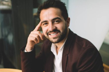 Resmi olarak gülümseyen yakışıklı iş adamının portresi internette sohbet etmek için cep telefonu kullanıyor, kafenin içinde mola veriyor, kameraya bakan başarılı erkek girişimci cihazların keyfini çıkarıyor.