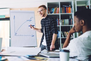 Beyaz kuruldaki seminer sırasında gülen genç iş arkadaşlarından oluşan neşeli bir ekip başarılı erkek ve kadın üniversite öğrencilerine danışmanlık yapan gülümseyen bir adam kapalı alanda kendini iyi hissediyor.