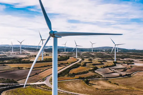 Türbin ve pervaneler ile yel değirmenlerinin havadan görünümü, tarımsal kırsal alanlar alanında Rüzgar elektrik istasyonları ve sistemleri için yeşil enerji üretiyor. Alternatif enerji üretimi