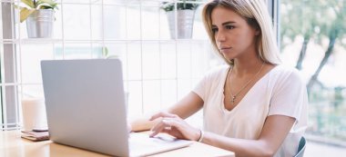 Web makalesi, modern netbook üzerinde tarama internet sırasında sosyal ağda ciddi kadın okuma haber için Download medya dosyası iken sarışın kadın Freelancer dizüstü bilgisayarda yazılım güncelleme