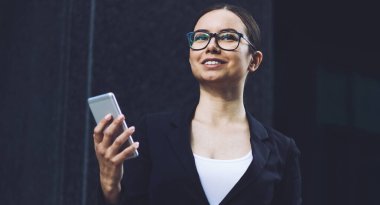 Neşeli kadın resmi giyim canlı akıllı telefon Gadget 'ı kullanarak gurur CEO 'su hakkında iyi haber ile alınan e-posta mutlu hissediyor giyinmiş, el uzak görünümlü ve gülümseyen iş kadını