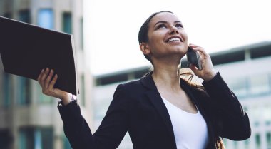 İş ortakları cep telefonu ile arama iyi bir anlaşma yaptıktan sonra heyecanlı şirket etek elbise hissi heyecanlanan kadın girişimci gülümsüyor. İş kadını elde sonra başarı kutluyor