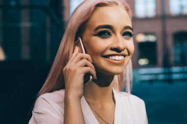 Arkadaş canlısı akıllı telefon konuşmaları sırasında gülen pembe saçlı neşeli hippi kız. Yüzünde tatlı bir gülümseme olan ve cep telefonuyla konuşan genç kız. Milenyum insanları.