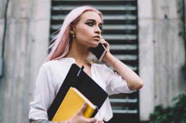 Ciddi çekici bir üniversite öğrencisi cep telefonuyla konuşuyor. Şehir sokağında duruyor. 20 'li yaşlarda güzel bir hippi kız ders kitabını tutuyor ve akıllı telefondan arıyor.