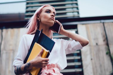 Ciddi milenyum gazetecilerinin elinde eskiz ve ders kitabıyla şehirdeki toplantı zamanını sorduğu için meslektaşlarına telefon eden şık hippi kız okulunun cep telefonuyla iletişim kuran...