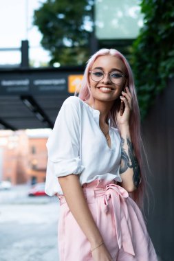 Şehrin boş zamanlarında arkadaşça telefon görüşmesi yapan neşeli hippi kızın yarım boy portresi. İnternete bağlanmış, iyi gümrük vergisiyle geziyor, pembe saçlı, pozitif bir genç kız arıyor.