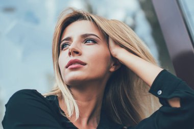 Gösterişli siyah tişörtlü, düşünceli, düşünceli, fikirlerini değiştiren, şehir bankında dinlenirken kaybolmuş, gündelik giysiler içindeki çekici hippi kız.