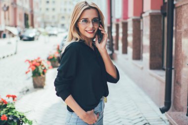 Moda güneş gözlüklü neşeli hippi kızın yarım boy portresi. Hafta sonunun tadını çıkarıyor. İletişim kurmak için interneti kullanıyor, modern dijital cihazlarla konuşan kaygısız kadın turist.