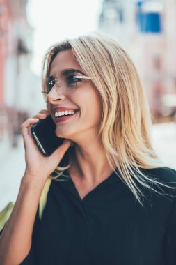 Cep telefonu iletişimi sırasında cep telefonuyla iletişim kurarak kendini iyi hisseden samimi bir bayan turist, modern bir cihazla konuşan sevimli gülüşlü olumlu bir kadın, jenerasyon konsepti.