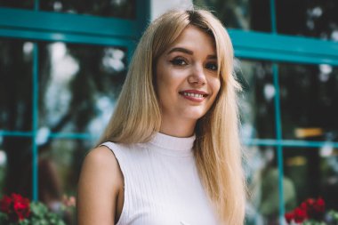 Masada otururken ve açık kafede panoya notlar yaparken güzel genç kadın gülümseyen ve kamera bakıyor