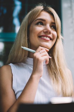 Güzel genç kadın gülümseyen ve şehir sokak güneşli bir gün panoya notlar yazarken rüya yüzü ile uzakta bakıyor