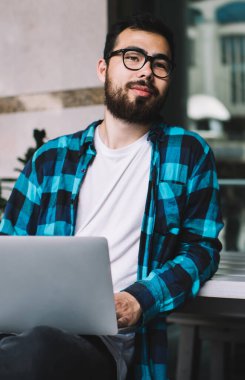 Düşünceli erkek serbest yazar, modern dizüstü bilgisayarlı gazeteciler için web sitesinde yayınlama fikri üzerinde kafa yoruyor. Görme düzeltmesi için optik gözlük takan düşünceli Asyalı adam.