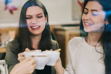 Mutlu neşeli kadınlar, canlı iletişimden ve kahve molasından mutlu hissediyorlar. Modern teknoloji ile yeni bir başlangıç projesi planlarken, pozitif kadın partnerler arkadaşlığın tadını çıkarıyorlar.