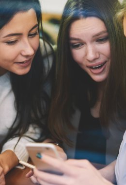 Wi-fi bölgesinde birlikte zaman geçirirken akıllı telefon uygulaması üzerinden sevimli medya dosyalarını izleyen neşeli refah kadınları, cep telefonuyla olumlu e-postalar okuyan mutlu hippi kızlar.