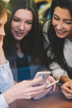 Heyecanlı, kendini iyi hisseden hipster kızları hoş içerikli, neşeli kadınların internetten cep telefonlarıyla internete bağlı komik videolar izlediği kısa mesajlar aldılar.