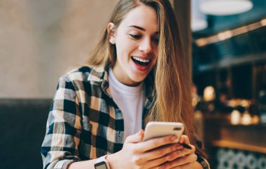 Mutlu hipster kızı, üniversite oturumuyla ilgili bilgilerin cep telefonuyla 4G kablosuz bağlantısıyla aldığı e-postadan şok olmuş hissediyor.