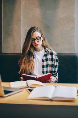 Üniversite sunumu için proje hazırlamak için çok yetenekli bir bayan öğrenci. Öğrenim sırasında bilgi edebiyatı üzerine araştırma yapıyor. Ders kitabından akıllı kadın okuma planı.