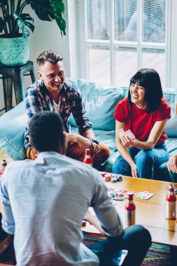 Neşe dolu dalgın hippilerden poker fişleri ile poker oynayıp modern dairede eğlenen