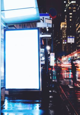 Reklam veya promosyon içeriği için boş kopya boşluk ekranı ile yağmurlu gece otobüs terminali Billboard, bilgi için lightbox kadar boş sahte, uzun pozlama ile kentsel şehir sokakta boş ekran